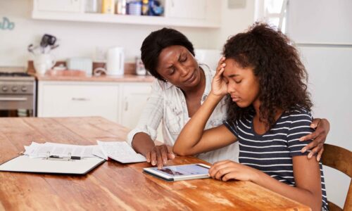Mother Helps Stressed Teenage Daughter With Homework